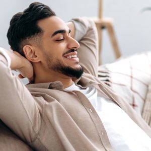 Chilling and relaxing at home. Handsome happy calm indian or arabian guy in casual clothes resting