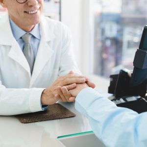 Pharmacist doctor supporting customer client buyer, listening attentively to her medical complaints